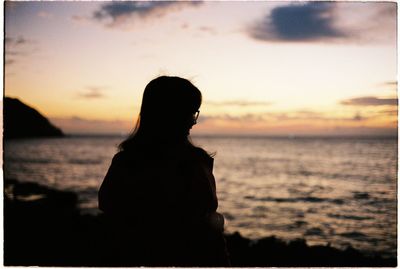 Silhouette of woman at beach during sunset