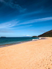 Scenic view of beach against blue sky