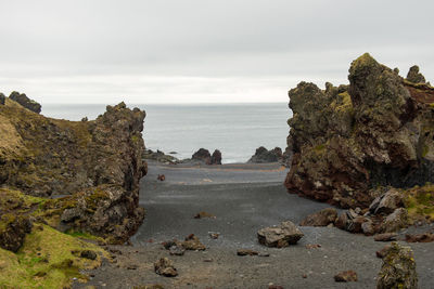 Scenic view of rocks on beach against sky