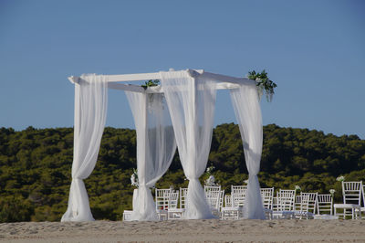 Wedding baldachine at beach against blue sky