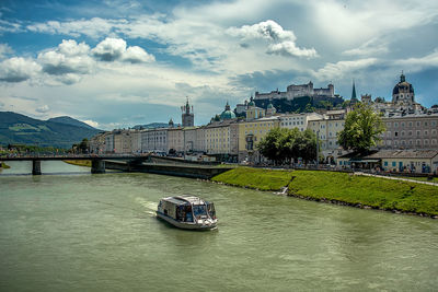 Bridge over river in city against sky