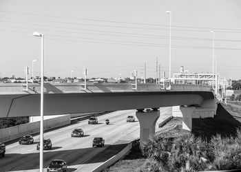 Cars on bridge against clear sky