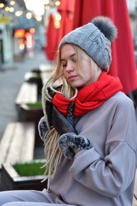 Woman looking away while sitting on bench