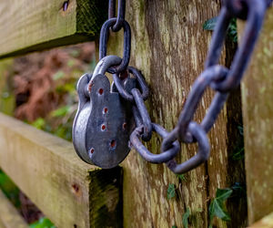 Close-up of chain hanging on metal fence