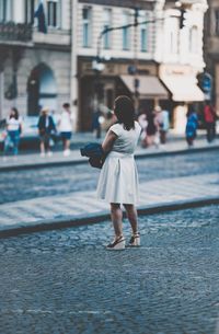 Rear view of woman walking in front of building