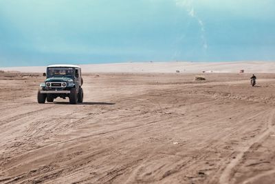 Tractor on desert against sky