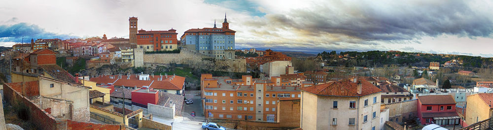 View of cityscape against cloudy sky