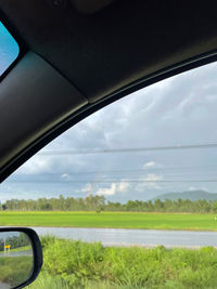 Scenic view of field against sky seen through car windshield