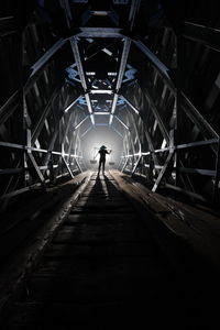 Rear view of person walking on bridge