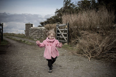 Full length of woman with pink umbrella against sky