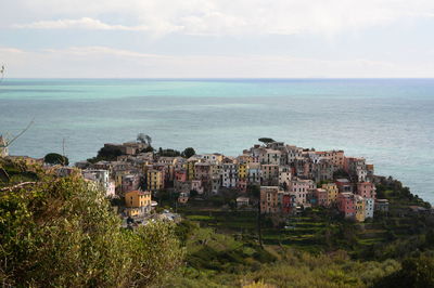Scenic view of sea by buildings against sky
