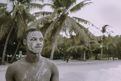 African american man with salt mask looking to the side at sunset on tropical beach in summer