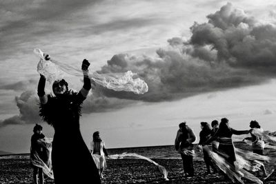 People at beach against sky