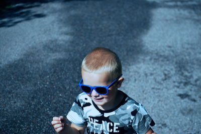 Boy wearing sunglasses while standing on road