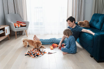 Cute preschooler boy and dad making diy snuffle mats for their pets, domestic cat and dog