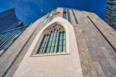 Low angle view of glass building against sky