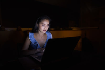 Mid adult woman using mobile phone at night