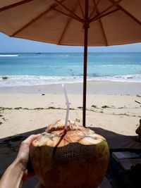 Person holding ice cream on beach