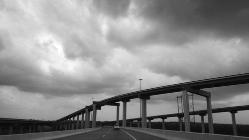 Bridge over river against cloudy sky