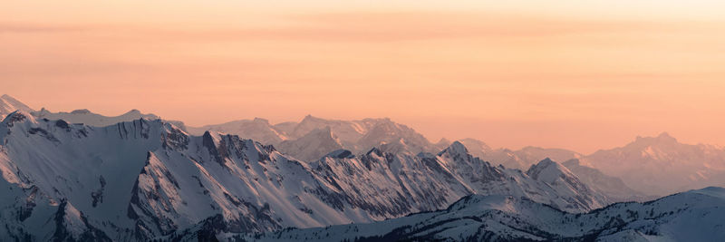 Scenic view of snowcapped mountains against sky during sunset