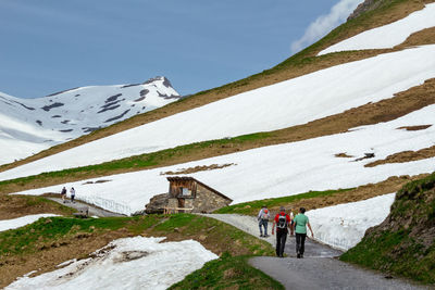 People on snowcapped mountain against sky