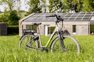 Bicycle on meadow in front of detached house