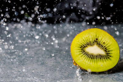 Close-up of wet kiwi on table