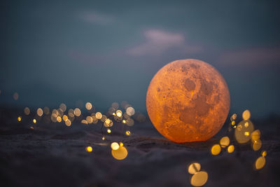 Close-up of wine on rock against sky at night