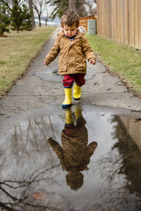 Full length of boy in puddle