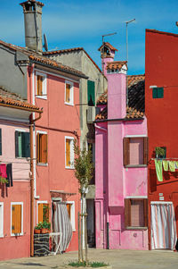 View of colorful houses on sunny day in burano, a gracious little town full of canals in italy.