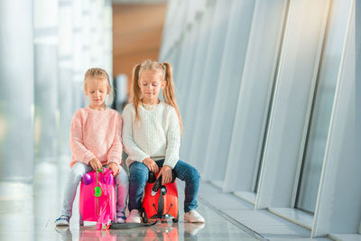 Close-up of happy girl with arms raised on floor