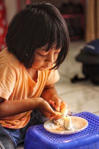 Side view of boy eating food at home