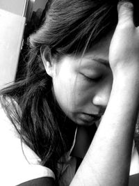 Close-up of mature woman with head in hands