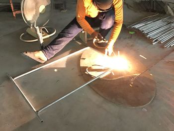 Low angle view of man working on metal