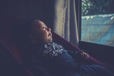 Close-up of boy relaxing in baby carriage at home