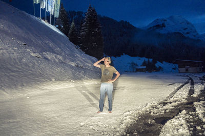 Man standing on snow covered road at dusk