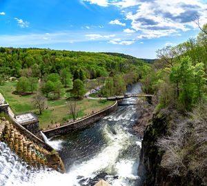 Scenic view of river amidst trees against sky