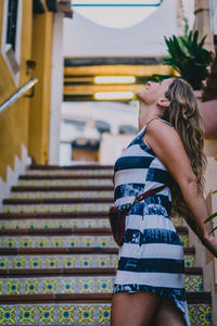 Woman standing by staircase