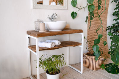 Modern design bathroom in ecological style. white walls, green plants, white bathrobes and towels