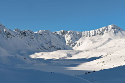 Scenic view of snowcapped mountains against clear blue sky