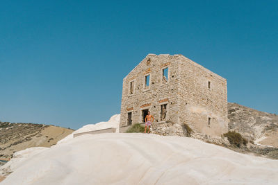 Low angle view of man standing by castle against blue sky