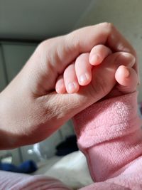 Cropped hand of parent holding baby