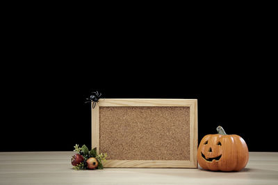 Close-up of pumpkin on table against black background