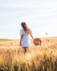 Woman standing on field against sky