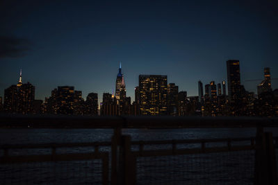 Illuminated buildings in city against sky at night