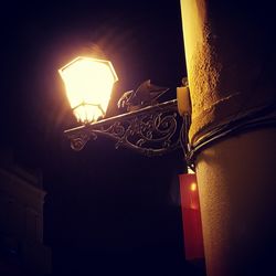 Low angle view of illuminated lamp at night