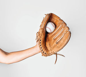 Baseball is caught in a worn baseball glove.
