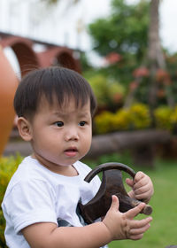 Portrait of cute boy holding baby outdoors