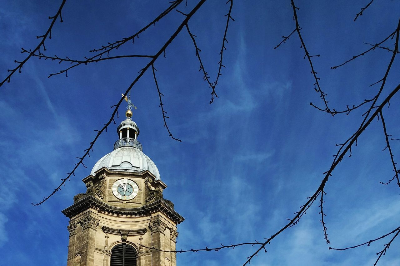 low angle view, religion, church, place of worship, architecture, spirituality, building exterior, built structure, sky, cathedral, tower, cross, blue, high section, cloud - sky, spire, steeple, day