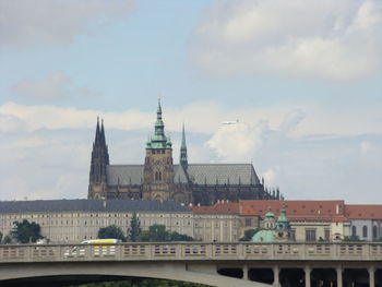 St vitus cathedral in prague against cloudy sky above the bridge